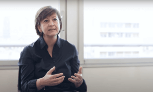 Une femme interviewée devant une fenêtre.